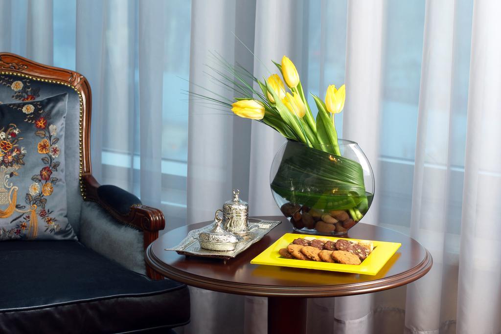 Orion Hotel Bisjkek Buitenkant foto A table with a vase of flowers